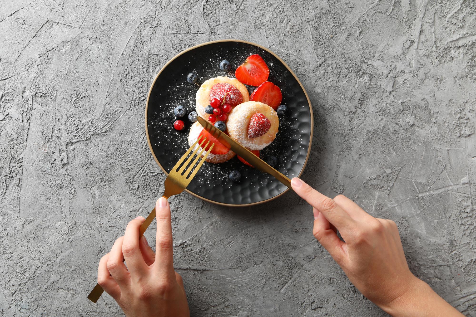 close-up of hands garnishing dessert
